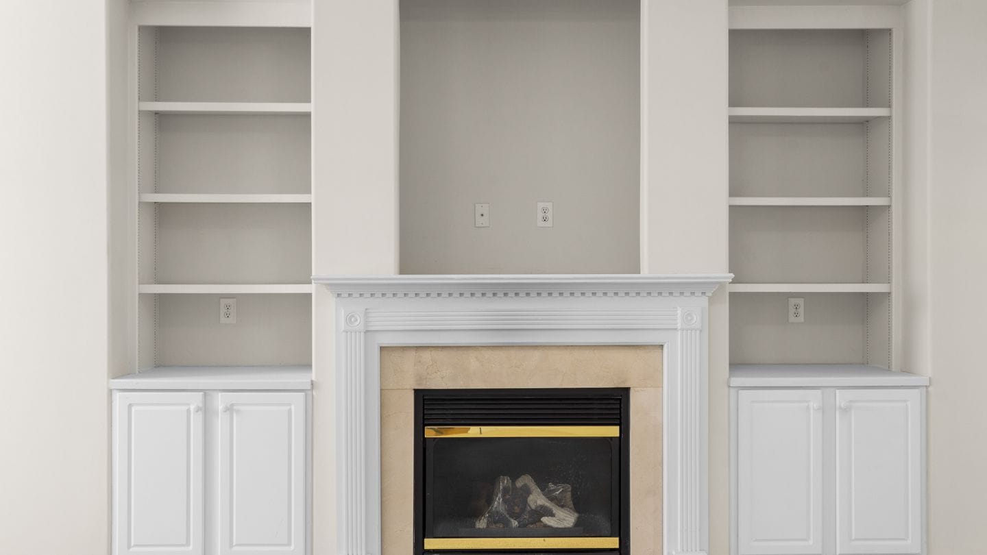 Built-in shelving and cabinets flanking a painted fireplace surround