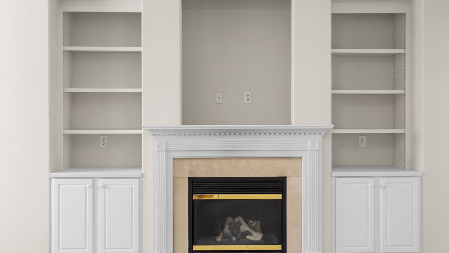 Built-in shelving and cabinets flanking a painted fireplace surround